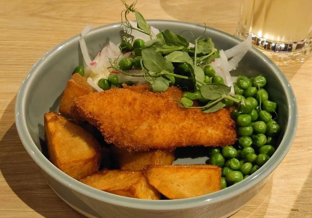 Crispy Breaded Fish Fillet with Cowboy Potatoes, Green Peas, and Fresh Radish Salad